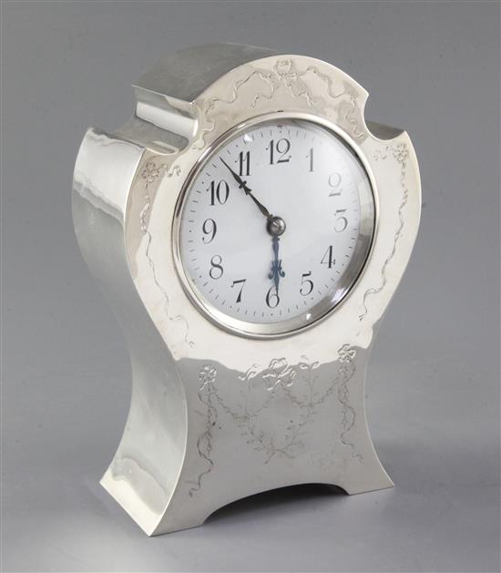 An Edwardian silver mounted shaped balloon cased mantel clock by William Comyns, 22.2cm.